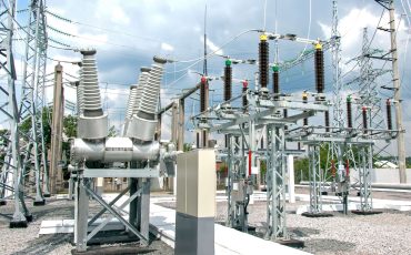 High-voltage electrical substation with transformers and insulators.