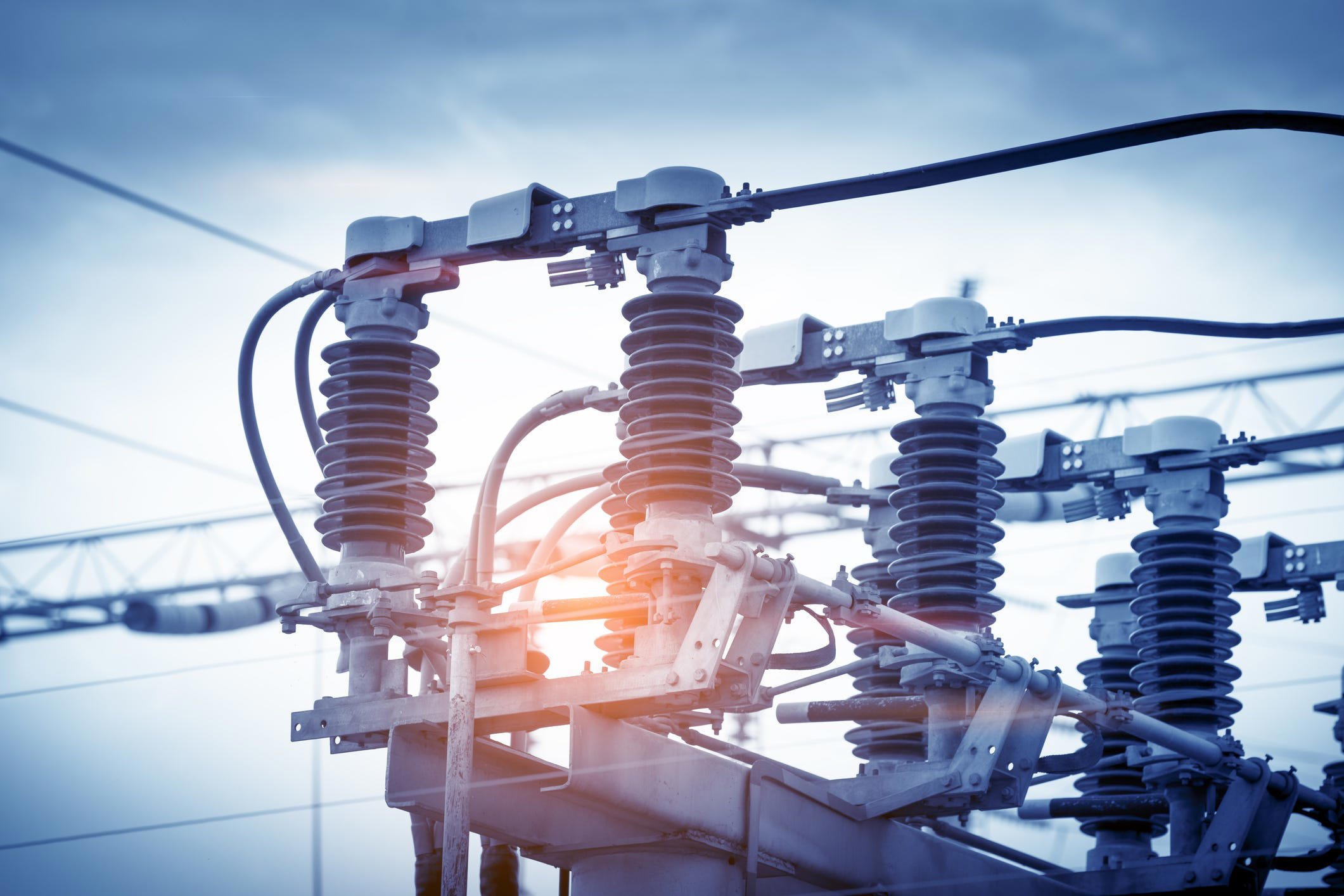 Close-up of electrical insulators and power lines at an electrical substation.