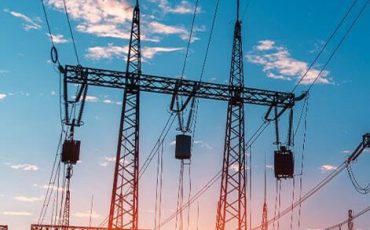 Electric power substation at sunset with clear blue sky.