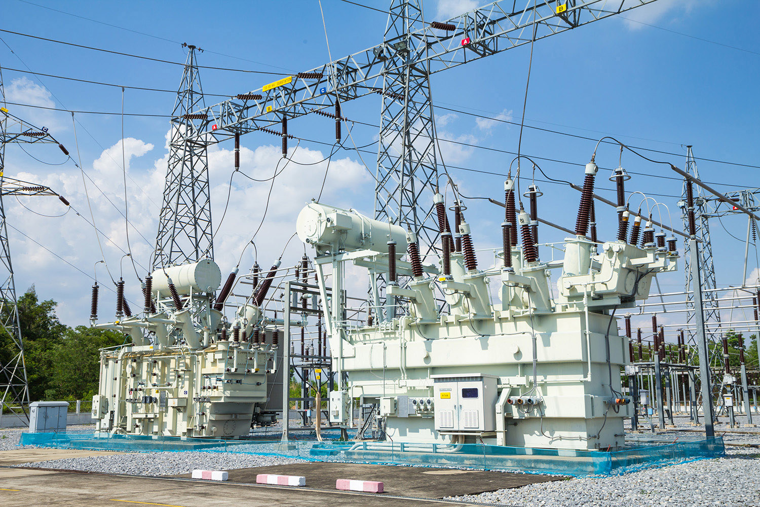 High-voltage electrical substation with transformers and power lines.